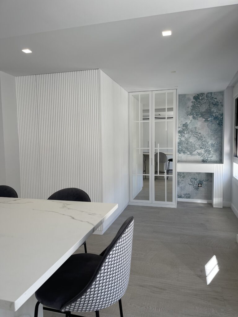 Muebles a medida para comedores, libreros, mesa de madera auxiliar y pared de listones de madera.